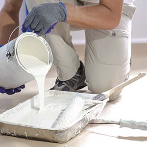 Alexander Fine Design Construction Painting Services - Person pouring paint into paint tray